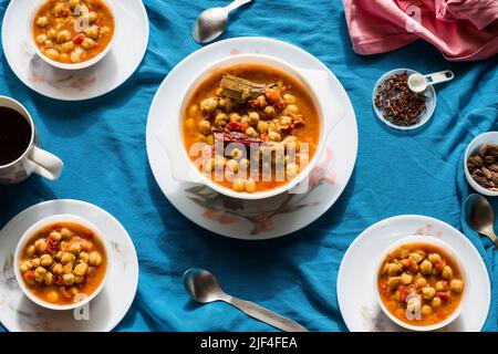 Vue de dessus de Chana Masala ou Choley ou de pois chiches sautés dans le beurre ou le ghee sur un fond bleu foncé. La sauce est épaisse a l'oignon, la tomate.Punjabi, Pakistanais. Banque D'Images