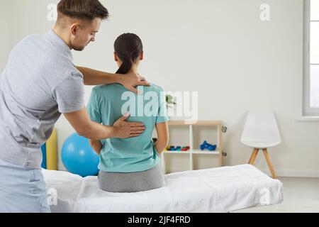 Médecine ostéopathique et physiothérapie. Ostéopathe examinant le retour de la femme dans le bureau de l'hôpital moderne, à proximité. Banque D'Images