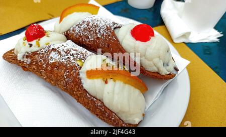 Sucré sicilien traditionnel fait maison, appelé cannoli, remplissage de la crème de ricotta, arrosée de sucre en poudre. Aux amandes, cerise, poire et fruit Banque D'Images