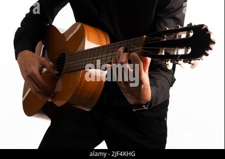 Guitare classique isolée et mains du guitariste se tunent de près sur fond blanc. Banque D'Images