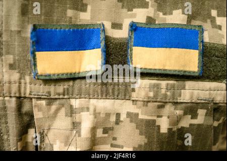 Chevrons sur l'uniforme de pixel militaire ukrainien, deux drapeaux bleus et jaunes. Banque D'Images