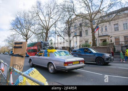 Un automobiliste affichant des drapeaux ukrainiens sur la voiture passe devant l'ambassade de Russie à Londres. Banque D'Images