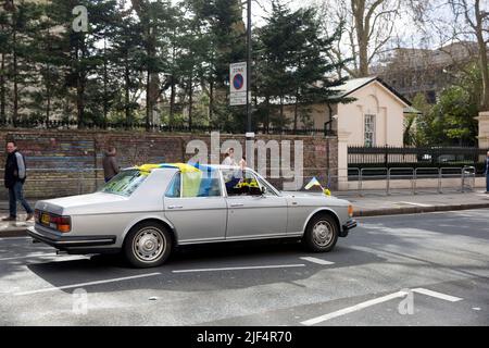 Un automobiliste affichant des drapeaux ukrainiens sur la voiture passe devant l'ambassade de Russie à Londres. Banque D'Images