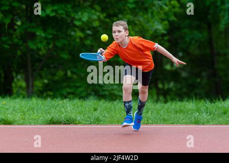 Enfant avec une raquette de tennis sur le court de tennis. Formation pour les jeunes enfants, enfants en bonne santé. Affiche horizontale sur le thème du sport, cartes de vœux, en-têtes, site Web et Banque D'Images