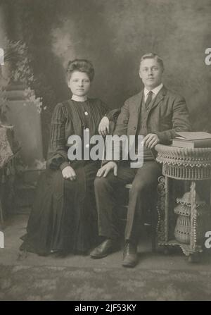 Photographie antique vers 1890s d'un jeune couple non marié dans ou près de Fitchburg, Massachusetts, États-Unis. Le même couple apparaît marié avec des anneaux en Alamy photo #2JF53MX. SOURCE : CARTE D'ARMOIRE PHOTOGRAPHIQUE ORIGINALE Banque D'Images