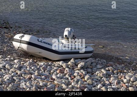 Petit pneumatique avec moteur hors-bord, tiré sur la rive, île de Tilos, près de Rhodes. Mai 2022 Banque D'Images