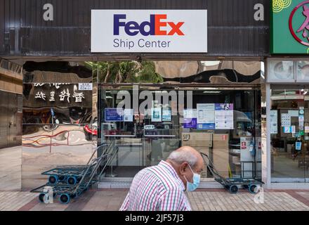 Un piéton passe devant le magasin de l'entreprise de livraison American FedEx Express à Hong Kong. Banque D'Images
