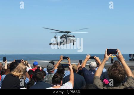 Les marins, leur famille et leurs amis observent un MH-60s Nighthawk, attaché aux “Tridents” de l’Escadron de combat de la mer (HSC) 9, lors de la croisière d’une journée entre amis et famille de l’USS Gerald R. Ford (CVN 78), à 25 juin 2022. Des amis et des membres de la famille ont été invités à bord de Ford pour faire l'expérience d'une journée dans la vie d'un marin en mer. (É.-U. Photo de la marine par le spécialiste des communications de masse 1st classe Julie R. Matyascik) Banque D'Images