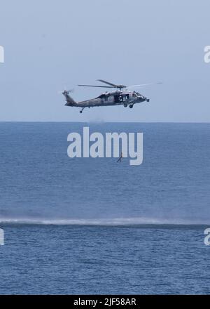 Un MH-60s Nighthawk, attaché aux “Tridents” de l’Escadron de combat en mer (HSC) 9, effectue une simulation de recherche et de sauvetage lors de la croisière d’amis et de famille de l’USS Gerald R. Ford (CVN 78), à 25 juin 2022. Des amis et des membres de la famille ont été invités à bord de Ford pour faire l'expérience d'une journée dans la vie d'un marin en mer. (É.-U. Photo de la marine par le spécialiste des communications de masse 2nd classe Jackson Adkins) Banque D'Images
