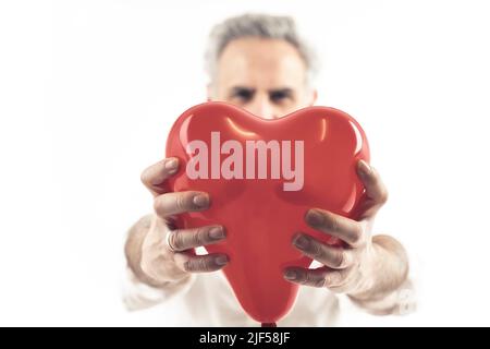 l'homme gris à cheveux d'âge moyen tient le ballon en forme de coeur isolé fond blanc moyen coup de feu . Photo de haute qualité Banque D'Images