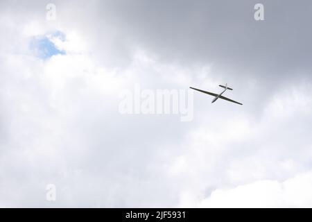 Le planeur sans moteur ne vole dans les nuages sombres sur les collines Banque D'Images