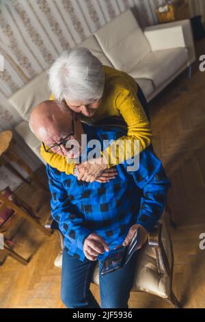Mignon couple caucasien utilisant un smartphone à la maison moyenne gros plan technologies modernes et l'ancienneté concept vertical tourné. Photo de haute qualité Banque D'Images