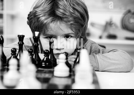 Petit garçon jouant aux échecs.Jeux éducatifs pour enfants, développement précoce pour les enfants.Garçon pense ou plan au jeu d'échecs, style vintage pour le concept d'éducation. Banque D'Images