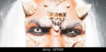 Esprit d'arbre et concept de fantaisie. Vieux barbu habillé comme un monstre d'Halloween. Extraterrestre avec une peau de dragon et une barbe grise. Monstre aux yeux bleus blancs Banque D'Images