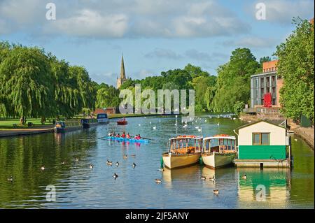 Vue le long de la rivière Avon, Stratford-upon-Avon, Warwickshire vers l'église de la Sainte-Trinité, avec des bateaux d'excursion d'une journée de tourisme amarrés. Banque D'Images