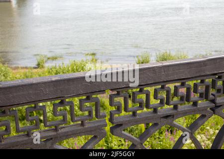 Conception technique de rampes en fonte noire en fer forgé de la clôture de remblai, près du fond de la rivière et de l'herbe sur le sho Banque D'Images