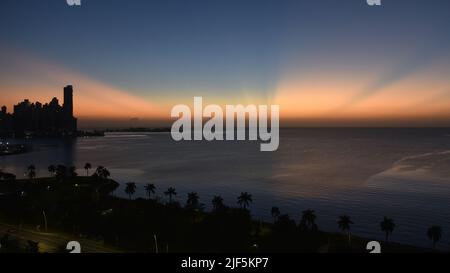 Magnifique lever de soleil sur une baie de Panama City avec des gratte-ciel et des cocotiers Banque D'Images