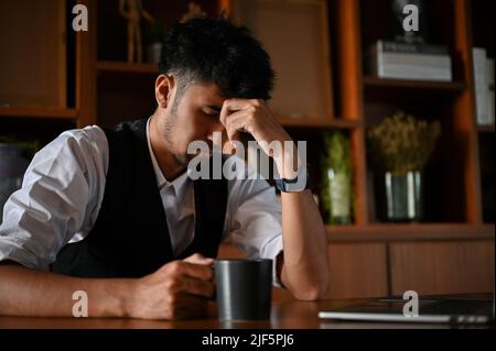 Fatigués et stressés, hommes d'affaires ou PDG asiatiques au bureau, contrariés et inquiets au sujet du chiffre d'affaires de son entreprise. Banque D'Images