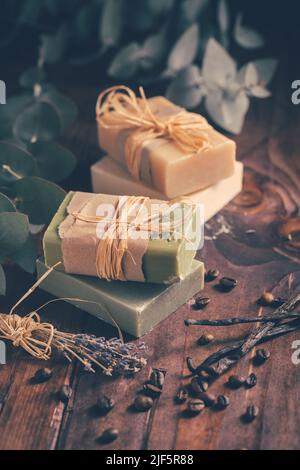 Barres de savon naturelles bio avec vanille, grains de café et eucalyptus sur fond de bois Banque D'Images
