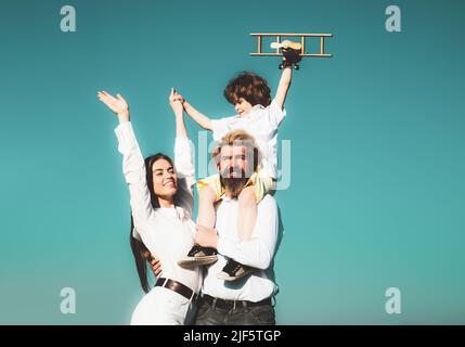 Bonne famille à l'extérieur. Famille gaie s'amuser à l'extérieur. Enfant jouant avec la mère et le père et s'amusant. Enfant avec avion jouet. Déplacement Banque D'Images