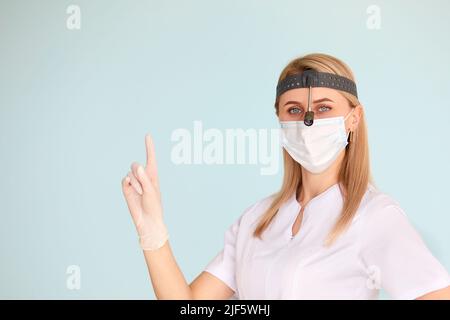 Femme médecin ORL, portant un masque à l'hôpital regardant la caméra Banque D'Images