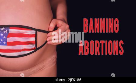 Inscription interdisant l'avortement et la femme enceinte sur fond noir avec masque médical et drapeau américain. Le concept de problèmes avec le coronavirus pendant la pr Banque D'Images