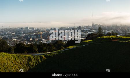 Vue depuis le sommet du Mont Eden avec le brouillard qui coule au-dessus de la Sky Tower et de la ville d'Auckland Banque D'Images