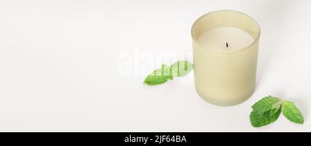 bougie de cire de soja avec feuilles de menthe, espace de copie, bannière. parfum d'intérieur, aromathérapie et détente à la maison. Banque D'Images