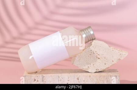 Bouteille cosmétique avec étiquette vierge sur pierre sur rose clair, feuille de palmier ombre dure derrière, gros plan, maquette. Produit de beauté pour les soins de la peau. Cosmétique naturelle Banque D'Images