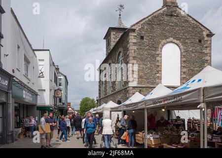 Les visiteurs se baladent dans les rues commerçantes de la ville de Keswick, dans le district du lac, à Cumbria Banque D'Images