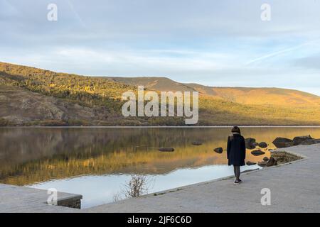 Femme au bord d'un lac reflétant les montagnes. Lac Sanabria. Banque D'Images