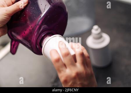 Femme remplaçant le filtre dans un pichet à eau. Une main femelle retire une ancienne cartouche de purification de l'eau du robinet d'une verseuse. Le processus de remplacement d'un ancien wat Banque D'Images