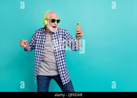 Photo de l'homme pudtier de hipster confiant ont plaisir à écouter la musique préférée bavarder avec des amis isolés sur fond turquoise couleur Banque D'Images