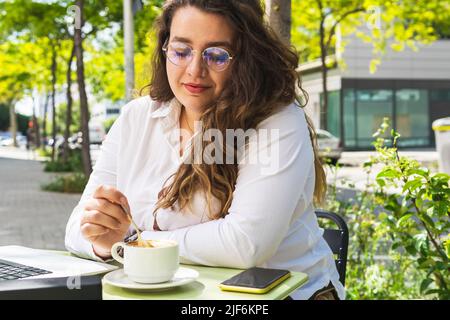 Faible angle de coursier femme heureux en uniforme et casque de navigation de téléphone portable tout en appuyant sur le bouton dans l'ascenseur Banque D'Images