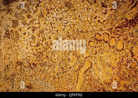 Vue aérienne plein cadre de l'arrière-plan abstrait avec des fissures sur la surface orange avec texture séchée Banque D'Images