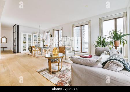 Intérieur d'une spacieuse pièce ouverte avec salon et salle à manger dans un appartement moderne en journée Banque D'Images