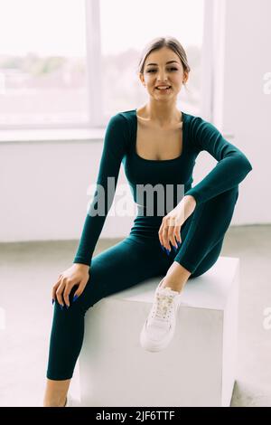 bien-construit sweaty fille faisant sauter la boîte au centre de sport. pleine longueur vue latérale photo. temps libre activité. Banque D'Images