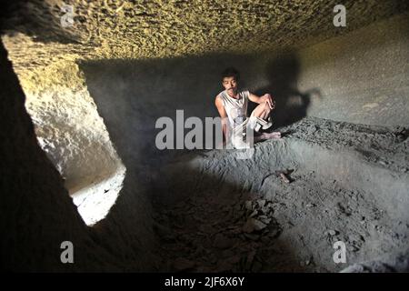 Un ouvrier est photographié alors qu'il se repose de creuser et de sculpter dans la roche pour construire une chambre pour la tombe traditionnelle de chambre de pierre dans le nord de Toraja, le sud de Sulawesi, en Indonésie. Banque D'Images