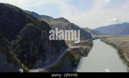 Voitures de circulation sur la route de Chuya entre les montagnes et la rivière Katun sous le ciel bleu à Altai, Sibérie, Russie. Magnifique paysage de nature d'été au du Banque D'Images