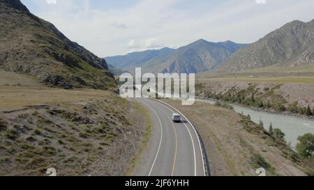 Voitures de circulation sur la route de Chuya entre les montagnes et le fleuve Katun à Altai, Sibérie, Russie. Magnifique paysage de nature d'été pendant la journée. A Banque D'Images