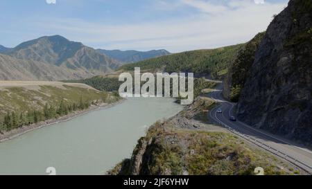 Voitures de circulation sur la route de Chuya entre les montagnes et la rivière Katun sous le ciel bleu à Altai, Sibérie, Russie. Magnifique paysage de nature d'été au du Banque D'Images