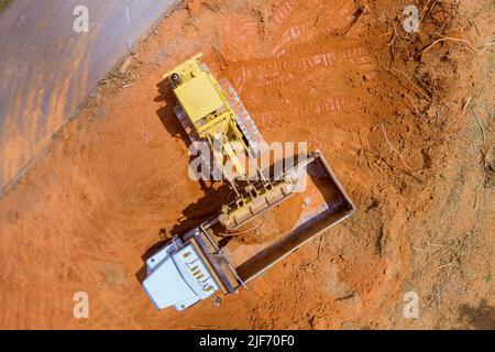 Les équipements de construction lourds travaillent avec le chargement de la terre dans le camion-benne via une pelle hydraulique Banque D'Images