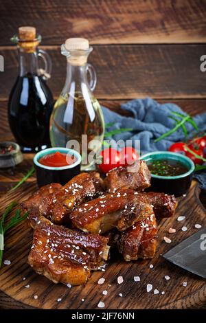 Côtelettes grillées en tranches de sauce aigre-douce. Côtes marinées dans de la sauce au miel avec des herbes Banque D'Images
