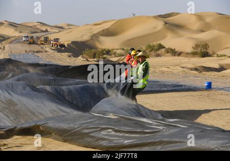 (220630) -- YULI, 30 juin 2022 (Xinhua) -- les travailleurs travaillent sur le site de construction d'une nouvelle autoroute traversant le désert de Taklimakan dans la région autonome de Xinjiang, au 5 juillet 2018, dans le nord-ouest de la Chine. Située dans la préfecture autonome mongole de Bayingolin, au sud du Xinjiang, l'autoroute reliant le comté de Yuli et le comté de Qiemo a été mise en service jeudi. L'autoroute est la troisième à travers le désert de Taklimakan, le deuxième plus grand désert de sable mobile au monde. Avec une vitesse prévue de 60 ou 80 km/h pour différentes sections, l'autoroute a une longueur totale de 334 km, avec 307 km pas Banque D'Images