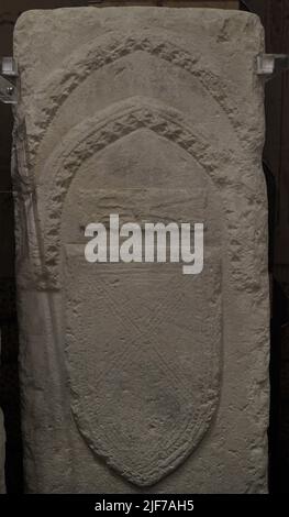 Détail d'une tombe médiévale appartenant à l'une des anciennes tombes d'un cimetière, qui n'existe plus, situé près de l'église Saint Augustin à Rabat (Victoria) sur l'île de Gozo, Malte. Selon la tradition, les pierres tombales marquèrent les tombes de personnalités illustres, civiles et ecclésiastiques, qui accompagnèrent le roi Louis IX de France dans sa croisade contre Tunis en 1270. Les navires français de retour ont été dispersés par une tempête. Certains de leurs équipages sont également morts de maladies. Plusieurs navires sont arrivés dans le port de Gozo, où les morts ont été enterrés. Musée d'archéologie de Gozo. Cittadela de Victoria Banque D'Images