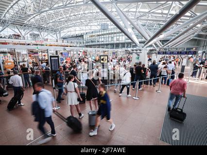 Hambourg, Allemagne. 30th juin 2022. Les voyageurs aériens attendent de longues files d'attente au point de contrôle de sécurité de l'aéroport de Hambourg. Avec le début des vacances d'été au Schleswig-Holstein, au Mecklembourg-Poméranie occidentale et à Hambourg, l'aéroport de la ville hanséatique s'attend à une ruée de passagers crédit: Christian Charisius/dpa/Alay Live News Banque D'Images