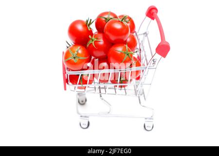 Chariot de poussée de jouet plein de tomates fraîches de cocktail isolées sur fond blanc. Banque D'Images