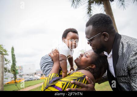 Famille africaine heureux ensemble, la mère lève bébé dans l'air. Banque D'Images