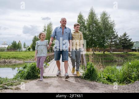 Le père marche avec les enfants dans la nature. Banque D'Images