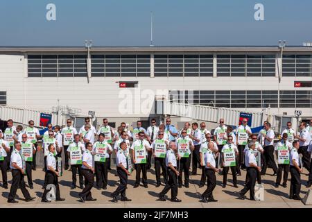 Detroit, Michigan, États-Unis. 30th juin 2022. Les pilotes de Delta Air Lines picket à l'aéroport Detroit Metro (DTW), protestant contre l'absence de progrès dans les négociations contractuelles. Ils veulent que les horaires des pilotes soient modifiés, disant qu'ils sont surchargés parce que la compagnie aérienne planifie plus de vols que ce qui peut être géré avec son nombre actuel de pilotes. Crédit : Jim West/Alay Live News Banque D'Images